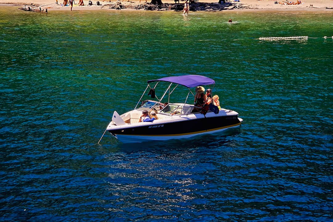 People relaxing on their Cobalt bowrider boat by the Emerald Bay in Lake Tahoe, California, USA.